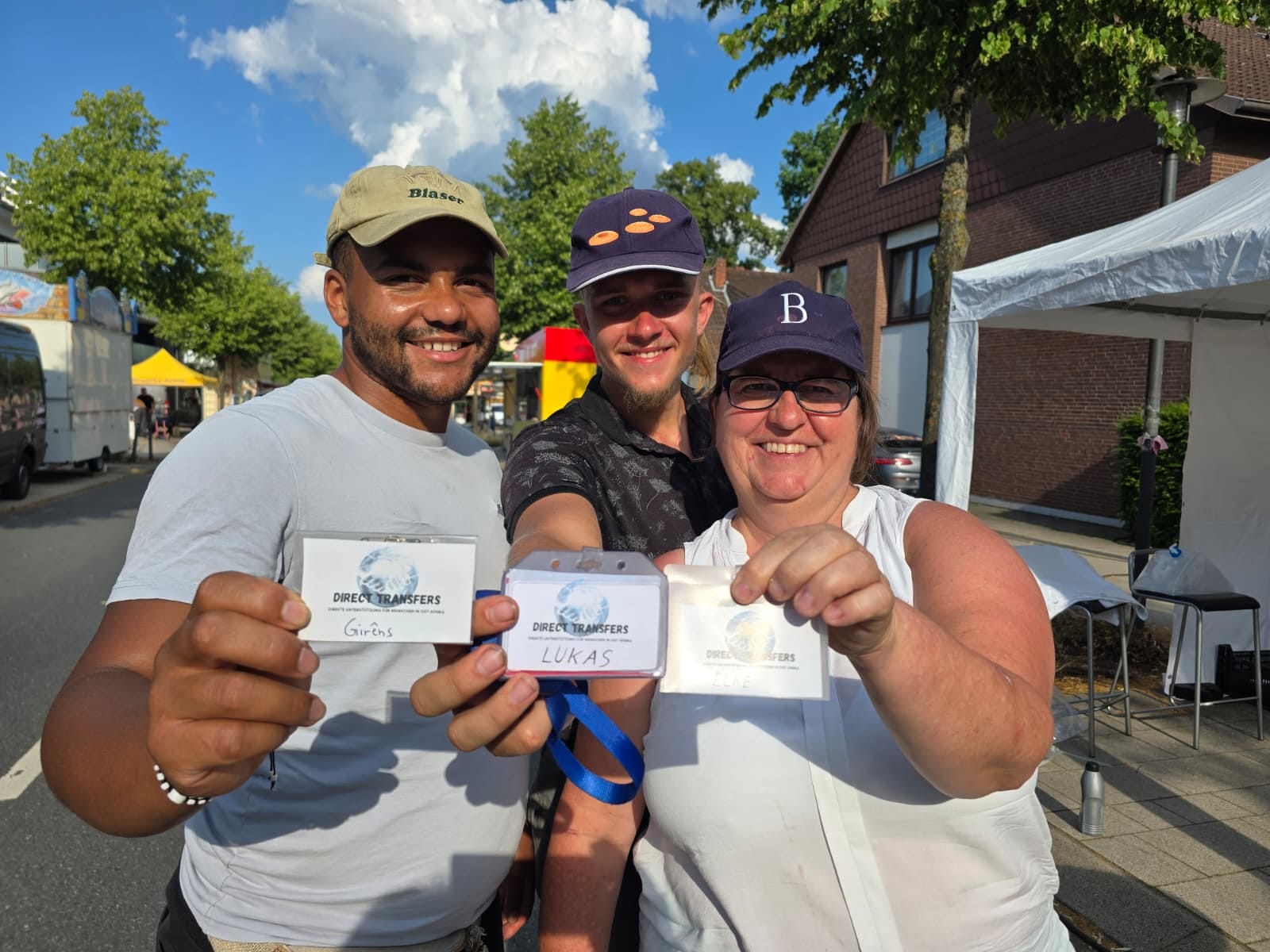 Three members of the association showing their business cards at the summer festival