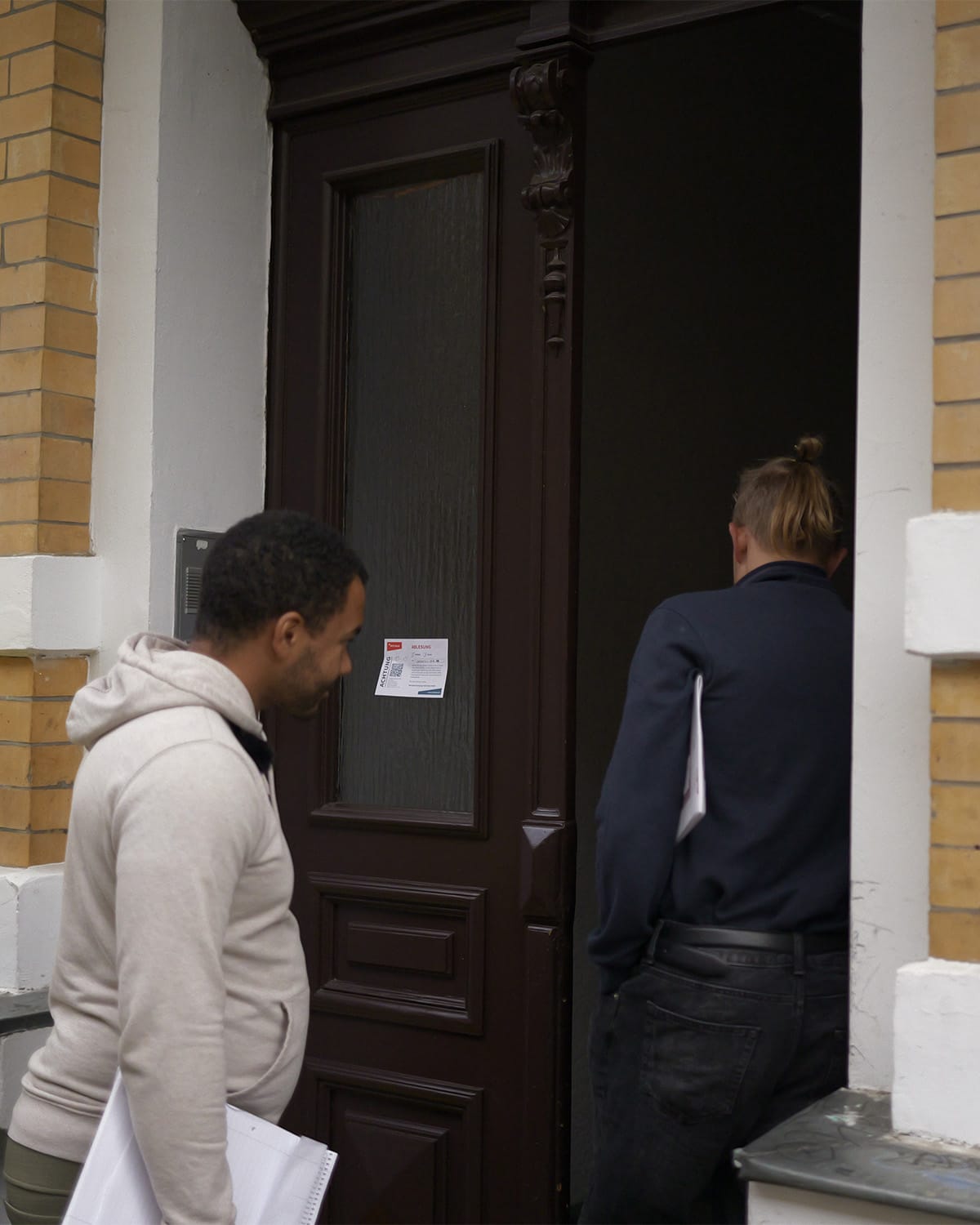Two members of the association ringing a doorbell
